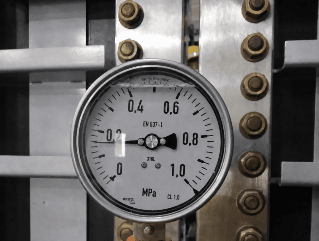 Industrial liquid-filled pressure gauge mounted on machinery