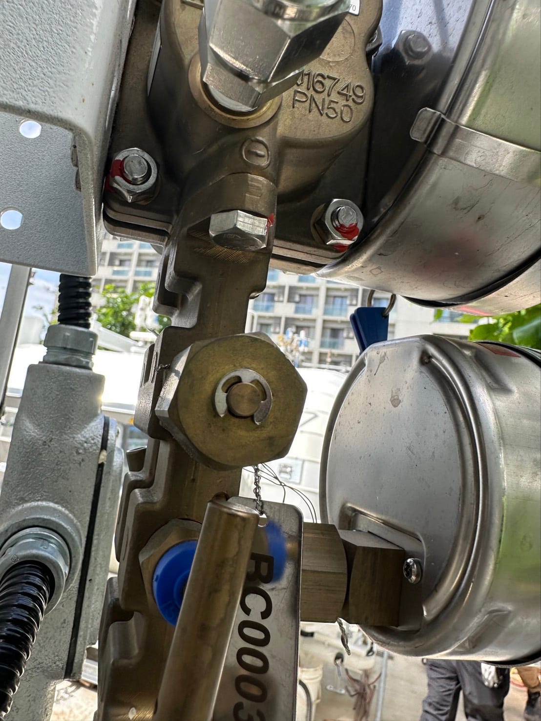 Rear pressure gauge connections and hexagonal fittings on a valve assembly